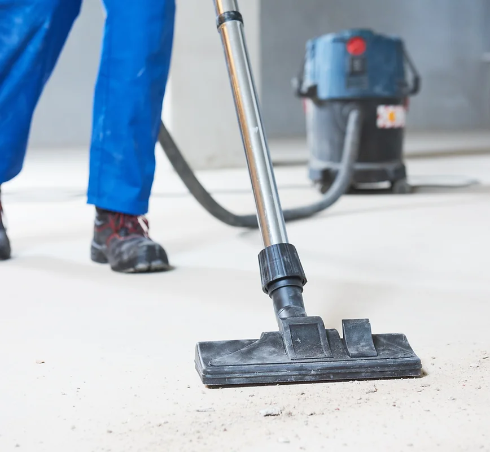 Person using shop vacuum to clean debris on floor