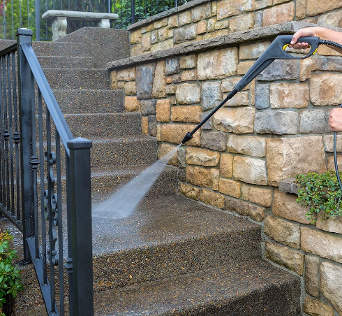 Person pressure washing outdoor stairs